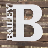Large wood letter 'B' with 'BAILEY' above it on a wooden background
