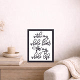 Framed artwork on a side table next to a sofa with decorative items.